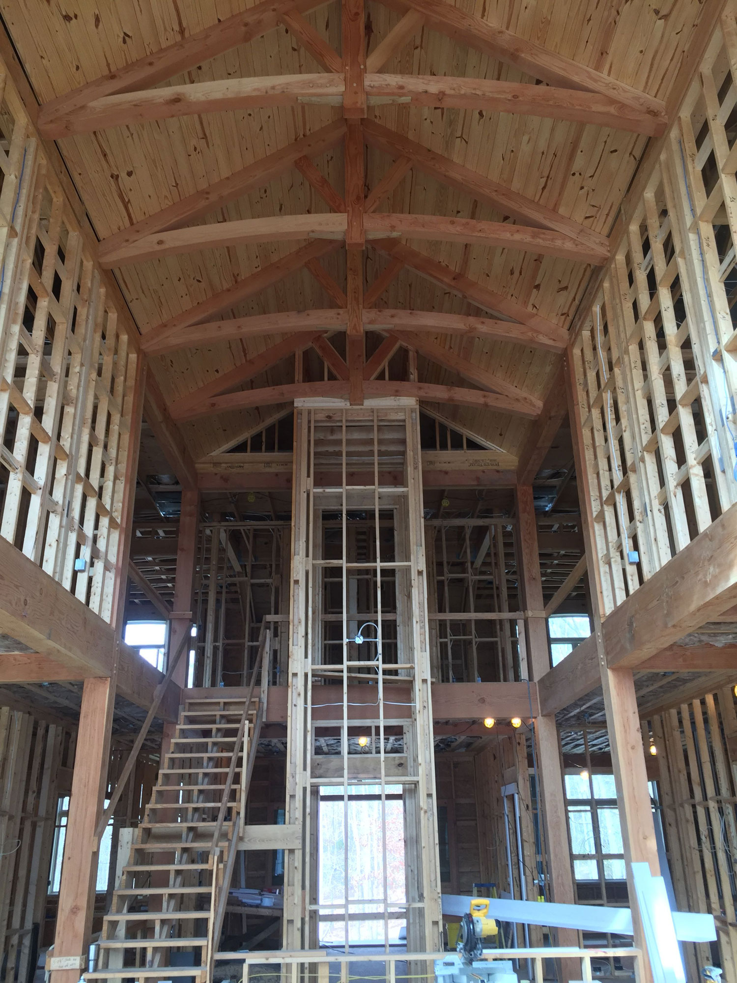 Custom Timber Frame Home Great Room Construction with Arched Chord King Post Trusses with Struts